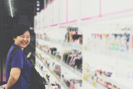 Asian woman with many types of cosmetics for beauty and skin health products for sale in supermarket open dailyの写真素材