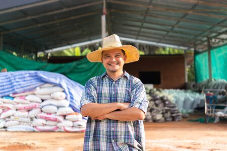 Asian man farmer agriculturist happy at a Fertilizer composting plant with Organic Fertilizer, Compost (Aerobic Microorganisms) from animal waste for use in the organic agriculture industryの写真素材