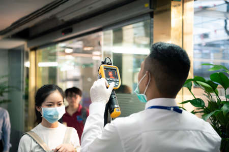 Bangkok, Thailand - March 16, 2020 : Unidentified people waiting body temperature check to access building for against epidemic flu covid19 or corona virus by thermoscan or infrared thermal cameraのeditorial素材