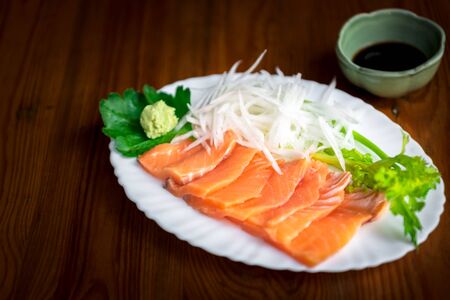 Japanese food delicacy consisting sashimi salmon of very fresh raw salmon fish sliced into thin pieces serving with radish sliced in japan restaurantの写真素材