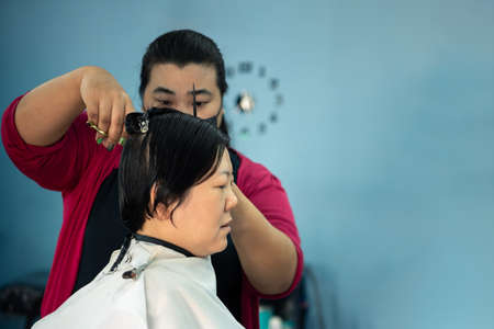 Bangkok, Thailand - February 2, 2020 : Unidentified asian woman hairdresser or hairstyle haircut a woman plump body customer in fashion hairstyle at barbershopのeditorial素材