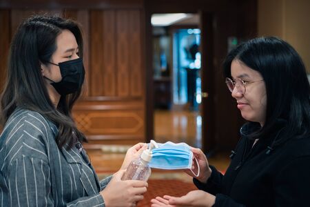 Asian women wearing mask and alcohol antibacterial hand gel respiratory protection mask against...