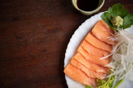 Japanese food delicacy consisting sashimi salmon of very fresh raw salmon fish sliced into thin pieces serving with radish sliced in japan restaurantの写真素材