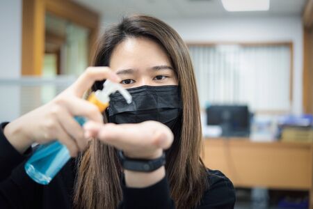 Asian woman wearing mask and alcohol antibacterial hand gel respiratory protection mask against epidemic flu covid19 or corona virus with fear emotion in concept illness, outbreak, healthcare in lifeの写真素材