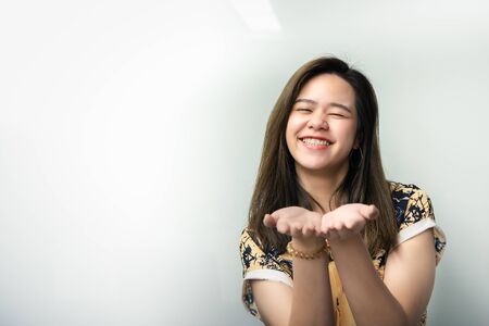 Asian pretty woman in cheongsam chinese style open the palm of the hand for want angpao or sharing with happy and smile in concept offer, give, sharing or receiveの写真素材