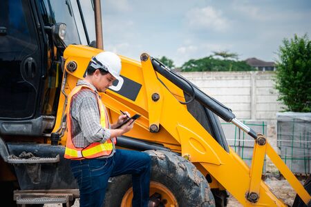 Asian man civil construction engineer worker or architect with helmet and safety vest working and...