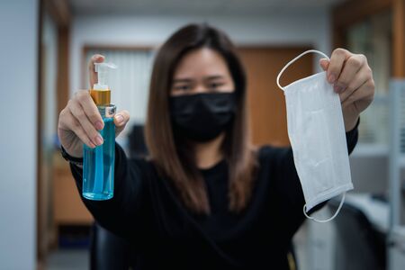 Asian woman wearing mask and alcohol antibacterial hand gel respiratory protection mask against epidemic flu covid19 or corona virus with fear emotion in concept illness, outbreak, healthcare in lifeの写真素材