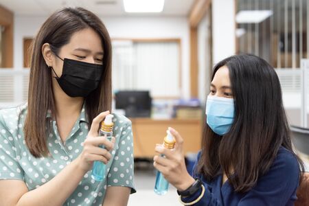 Asian women wearing mask and alcohol antibacterial hand gel respiratory protection mask against epidemic flu covid19 or corona virus with fear emotion in concept illness, outbreak, healthcare in lifeの写真素材