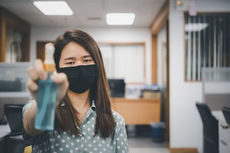 Asian woman wearing mask and alcohol antibacterial hand gel respiratory protection mask against epidemic flu covid19 or corona virus with fear emotion in concept illness, outbreak, healthcare in lifeの写真素材