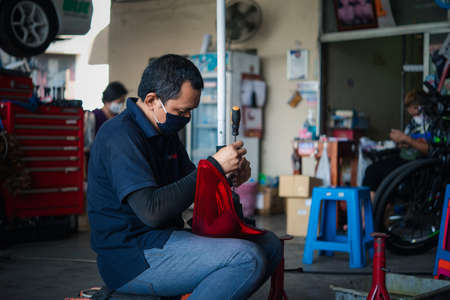 Bangkok, Thailand - April 4, 2020 : Unidentified car mechanic or serviceman checking a car engine for fix and repair problem at car garage or repair shopのeditorial素材