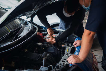Bangkok, Thailand - April 4, 2020 : Unidentified car mechanic or serviceman checking a car engine for fix and repair problem at car garage or repair shopのeditorial素材