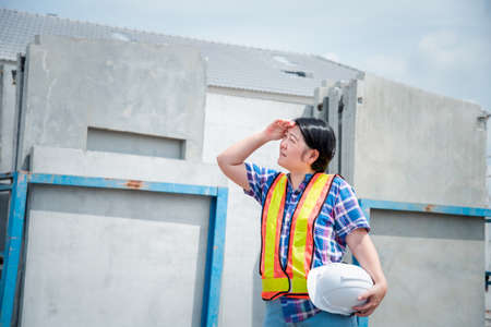 Asian woman civil construction engineer worker or architect with helmet and safety vest happy...