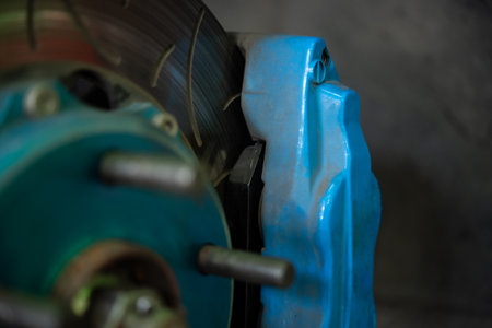 Car mechanic or serviceman disassembly and checking a disc brake and asbestos brake pads for fix and repair problem at car garage or repair shopの写真素材