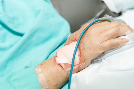 Patient asian elder woman 80s flu covid19 with pulse gauge for heartbeat measuring and blood pressure on a patient elderly finger on patient bed in intensive care unit (ICU.) room at hospitalの写真素材