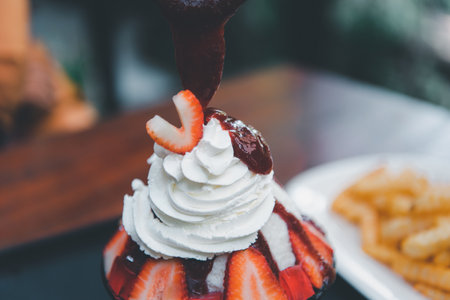 Bingsu or Bingsoo (Patbingsu) is a popular Korean shaved ice dessert with sweet toppings that may include chopped fruit, condensed milk, fruit syrup, and varieties with ingredientsの写真素材