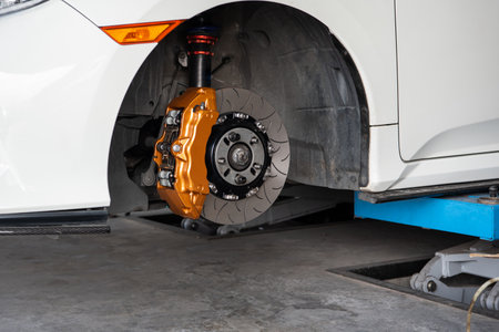 Car mechanic or serviceman disassembly and checking a disc brake and asbestos brake pads for fix and repair problem at car garage or repair shopの写真素材