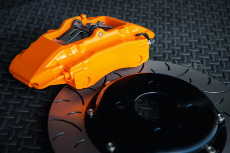 Car mechanic or serviceman disassembly and checking a disc brake and asbestos brake pads for fix and repair problem at car garage or repair shopの写真素材