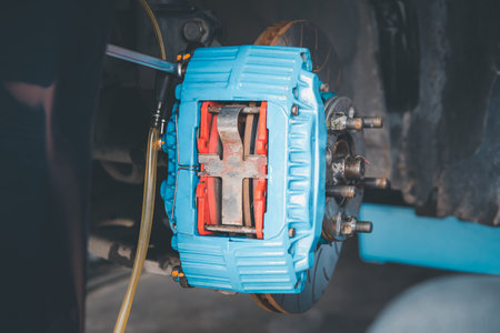 Car mechanic or serviceman disassembly and checking a disc brake and asbestos brake pads for fix and repair problem at car garage or repair shopの写真素材