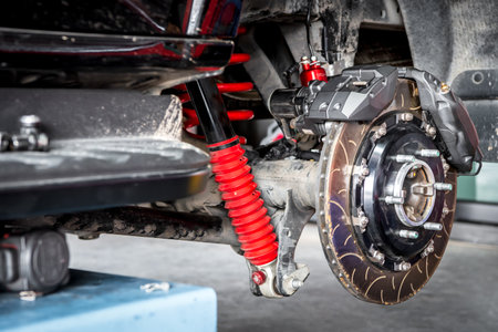 Car mechanic or serviceman disassembly and checking a disc brake and asbestos brake pads for fix and repair problem at car garage or repair shopの写真素材