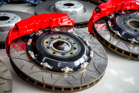 Car mechanic or serviceman disassembly and checking a disc brake and asbestos brake pads for fix and repair problem at car garage or repair shopの写真素材