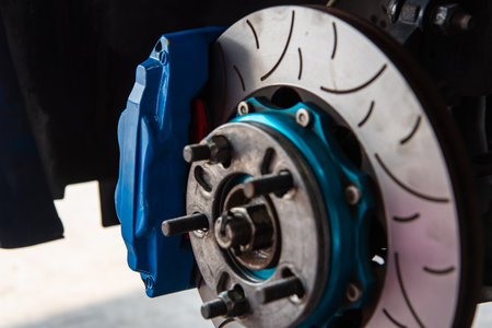 Car mechanic or serviceman disassembly and checking a disc brake and asbestos brake pads for fix and repair problem at car garage or repair shopの写真素材