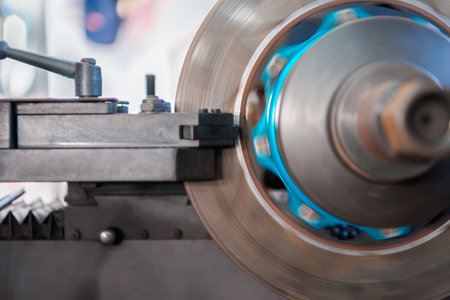Car mechanic or serviceman disassembly and checking a disc brake and asbestos brake pads for fix and repair problem at car garage or repair shopの写真素材