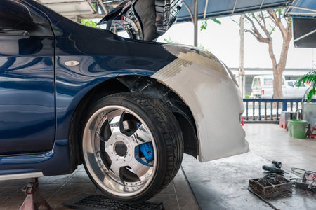 Denter or car mechanic serviceman check and fix body work and fiber bumper body part for fix and...
