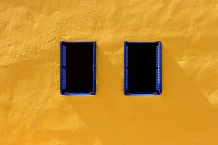 Two windows on orange wall