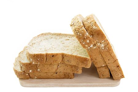 whole grain bread and slices on wooden cutting board and on white background