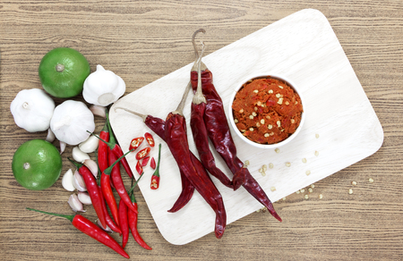 Asian herb and spicy with Chilli, garlic, lime, dried chili and curry paste on wooden Chopping board.の写真素材