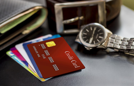 Credit card, wallet, watch and belt on the table, prepared to work or trip.