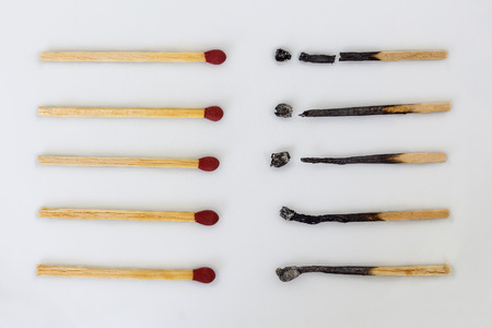 Burnt matchsticks and new matchsticks on white background. Different stages of matchsticks.の写真素材