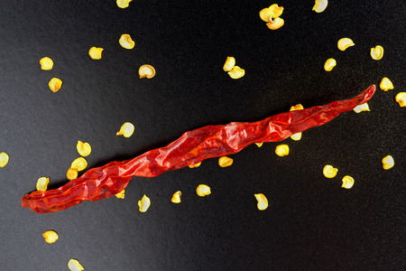 Closeup of red dry chili peppers on black background.