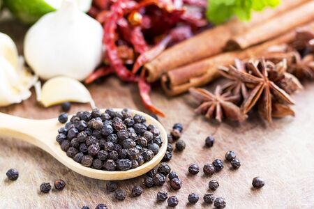 black peppercorns on wooden spoon.  closeup dried seeds.の写真素材