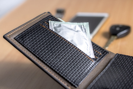condoms put inside wallet on wooden table. Safe sex conceptの写真素材