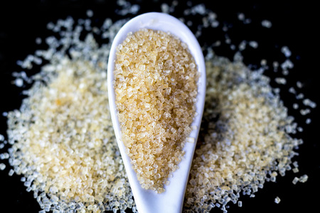 Full spoon of sugar isolated on black background.の写真素材