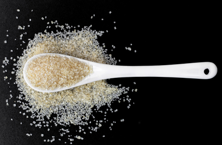 Full spoon of sugar isolated on black background.の写真素材