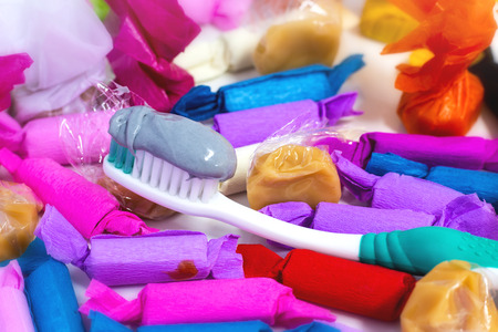 Many candies and herbal toothpaste on the table. Candies with the wrapped in the colorful paper. Dental care concept.の写真素材