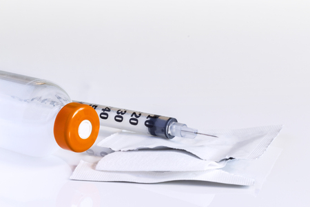 Injection vial, syringe and alcohol pad for disinfection on a white table. with copy space for your text.の写真素材