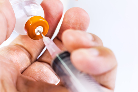 Medical syringe and injection vial in man hand. with copy space for your text. の写真素材