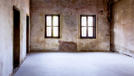 Overview of the empty room with old windows and doors. Abandoned empty room with the light shining through the window.の写真素材