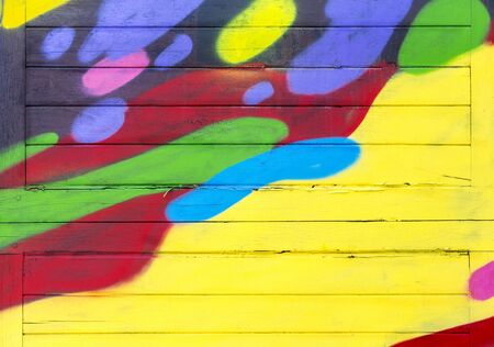 Old wood plank painted in red, yellow, blue, bright, and is a beautiful texture backgroundの写真素材