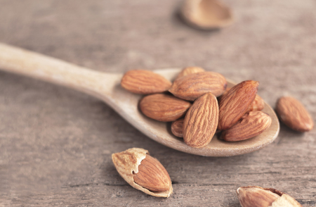 Almonds in the wooden spoon on the table. Almonds are rich in nutrients, vitamins and minerals that are essential to the body.の写真素材
