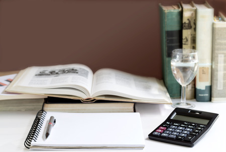 Open hardback and textbook stacked with a calculator on the table. The concept of intelligence comes from education. Selective focused の写真素材