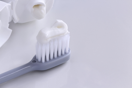 Toothbrush and toothpaste tube on the white table. Dental Care Concept. with copy space for your text.の写真素材