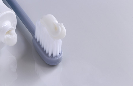 Toothbrush and toothpaste tube on the white table. Dental Care Concept. with copy space for your...