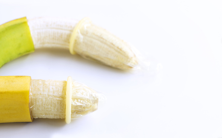 Condom onto the banana on white table background. The concept of safe sex. with copy space for your text.の写真素材