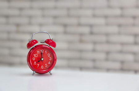 Red retro alarm clock on the white table. with copy space for your text and clipping path