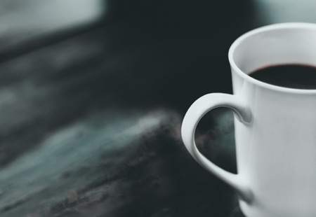 A cup of coffee was placed alone on a wooden table.  The concept of the lonely people heartbroken.の写真素材
