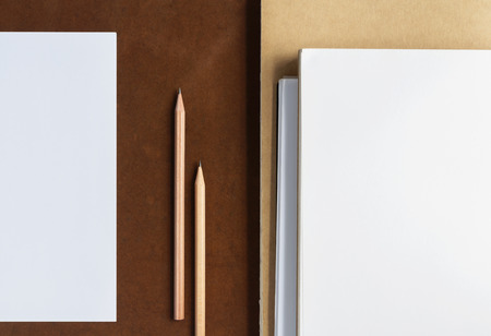 You can sketch or write text on white paper with a pencil placed on a brown wooden desk. Copy space for your text or image.の写真素材